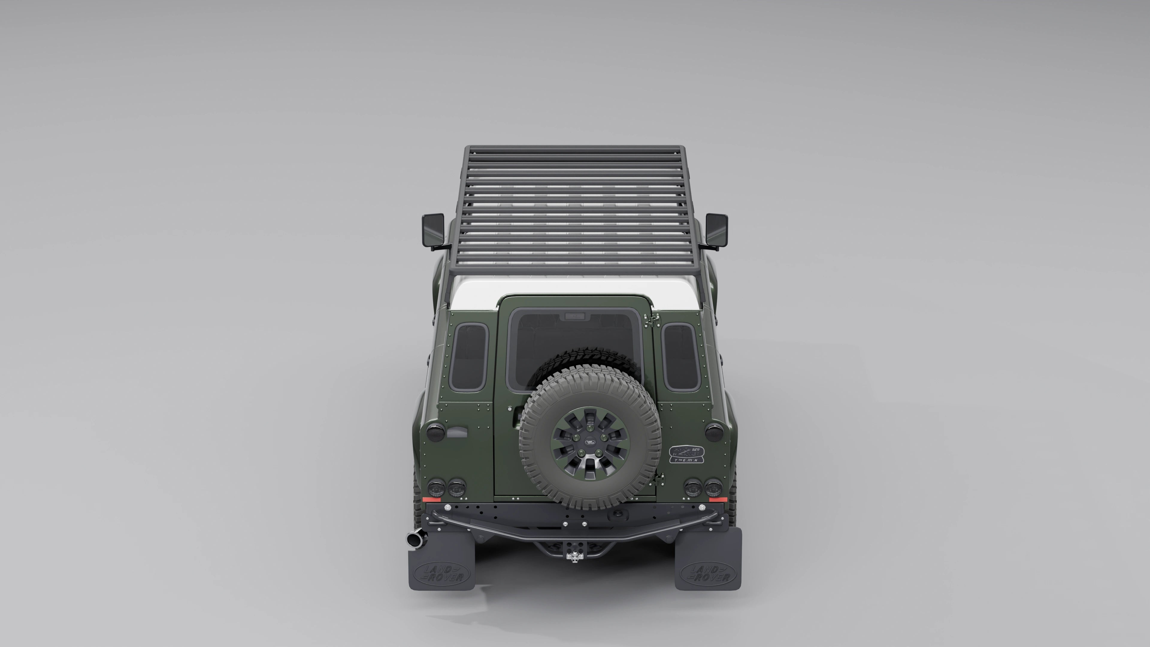 Direkte Heckansicht eines Land Rover Defender 110, die die gesamte Breite und flache Bauweise des schwarzen Expeditions-Dachträgers zeigt.