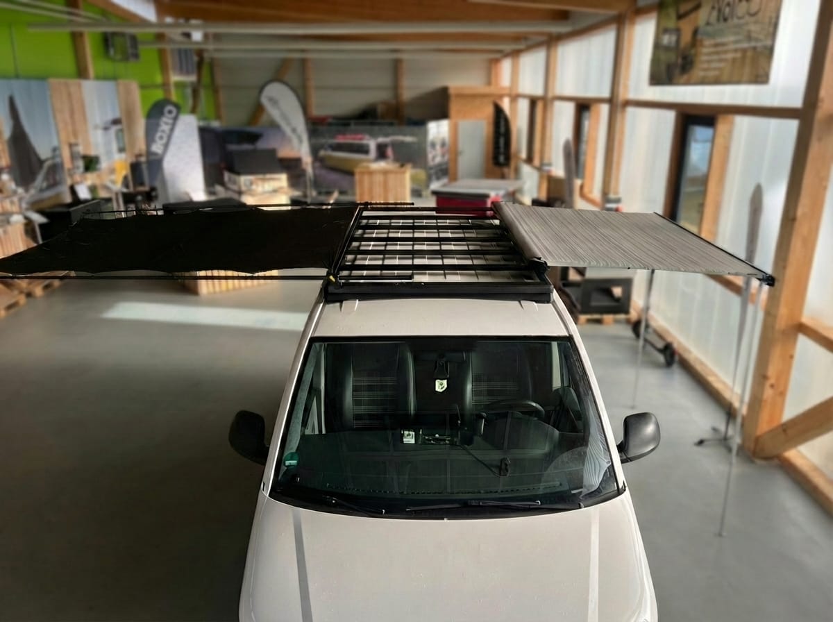 Weißer VW Bus (T5/T6) mit Airholder Dachträger, Aufnahme von oben auf den Dachträger mit montierter Fiamma Van Markise im ausgeklappten Zustand.